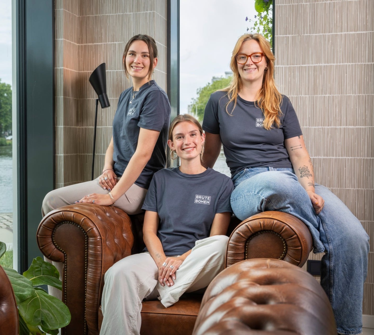 Portret van Sanne, Mica en Bo samen op de chesterfield in de bar.